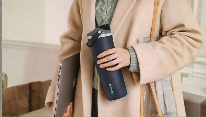 A girl holding a water bottle Owala Freesip Sway